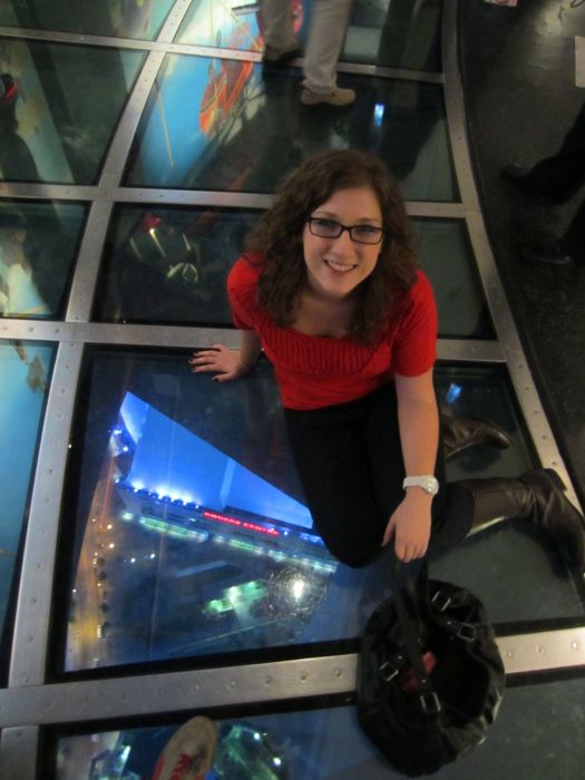 Nicole sitting on the glass floor in the CN Tower in Toronto